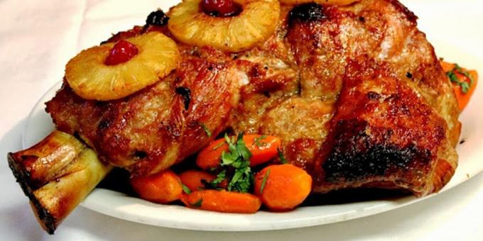 Carne di maiale nel forno: prosciutto di maiale con ananas, mandorle e prugne secche