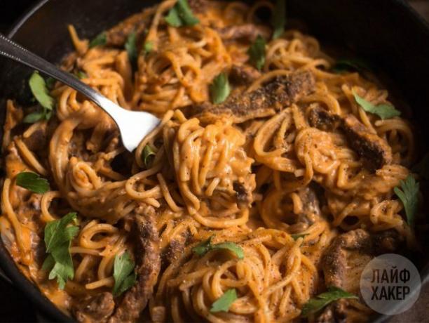 Pasta con manzo in salsa di crema di pomodoro, condita con prezzemolo e pepe