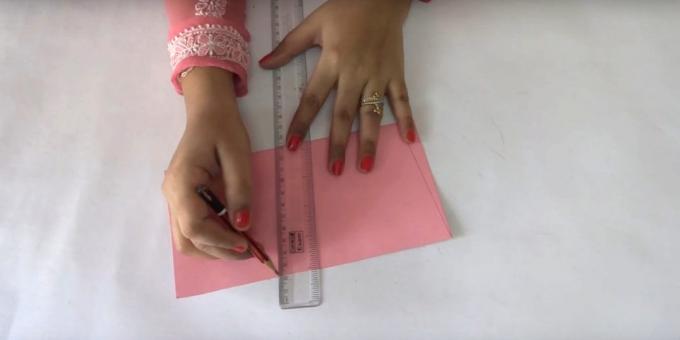 Piegare foglio rosa di carta a metà