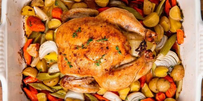 Un pollo intero in forno su un letto di verdure